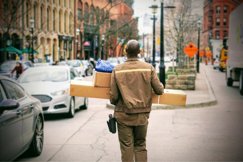 Courier carrying parcels down a street